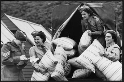 World War II servicewomen unloading pillows.